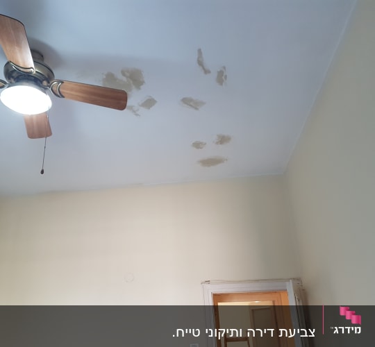 תקרה עם תיקוני צבע וטיח ליד מאוורר תקרה